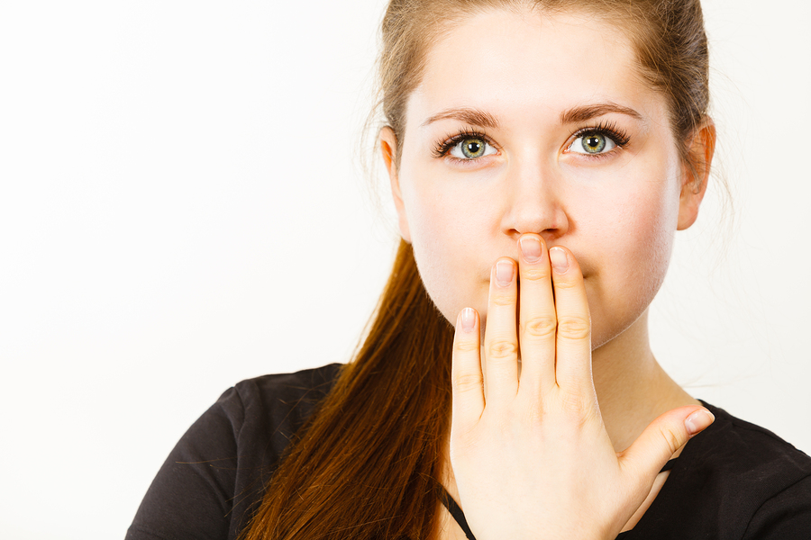 Woman covering her mouth with hand.