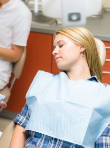 Woma asleep in teh dental chair from sedation