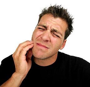man holding his jaw in need of an emergency dentist