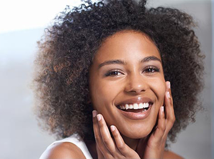 African American woman smiling, for information on facial aesthetics from Dr. Cha in Tulsa
